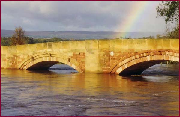 Bangor-on-Dee Bridge with the River Dee in full flood with Rainbow in background